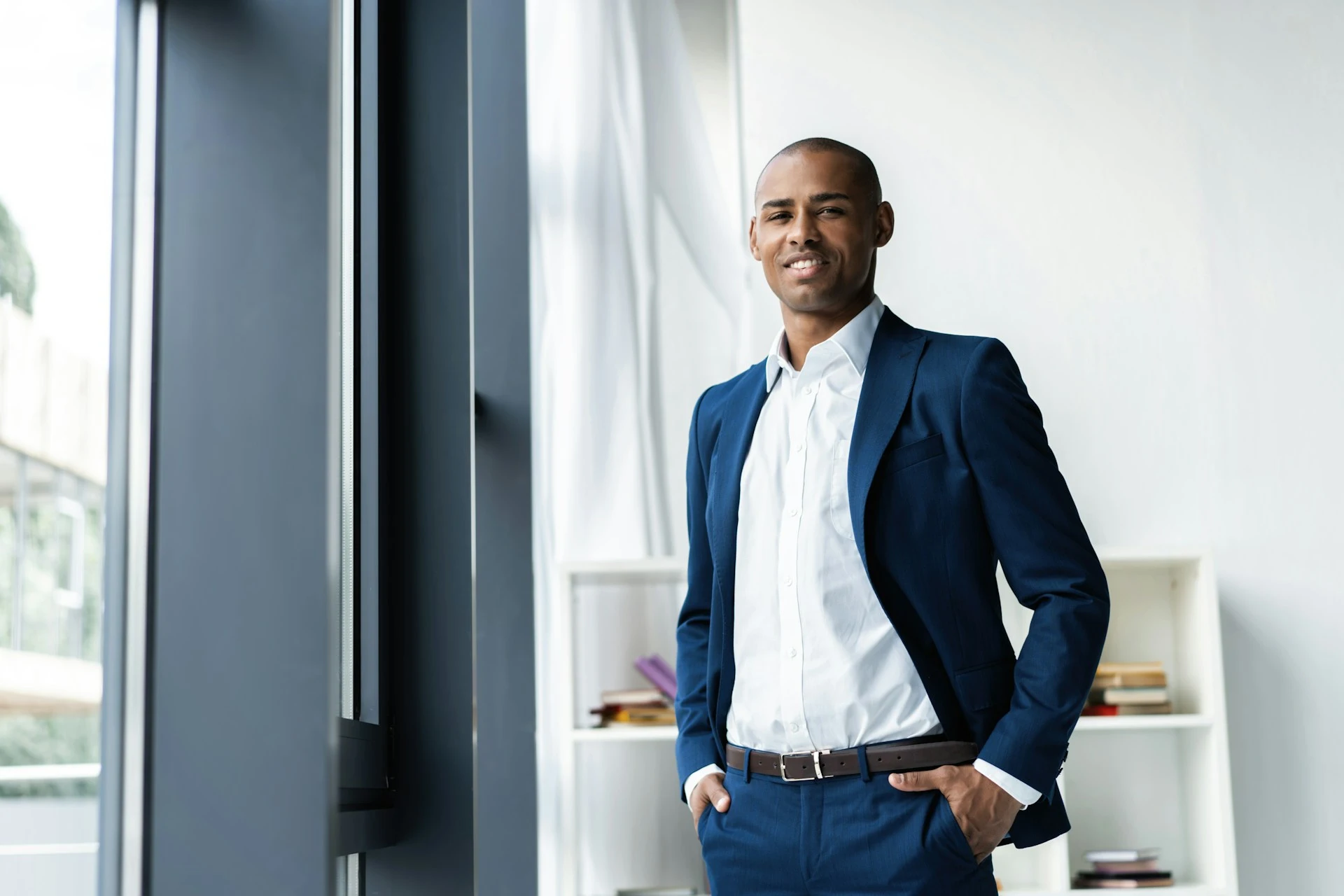 A man stands confidently in a suit before heading into a chief of staff job interview